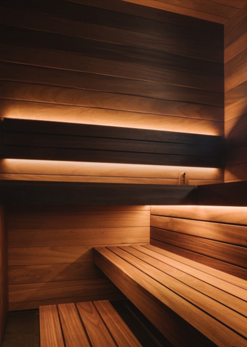 Interior of the Finnish-style cedar sauna with warm backlit benches