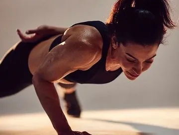 Member holding a push-up position in the infrared studio