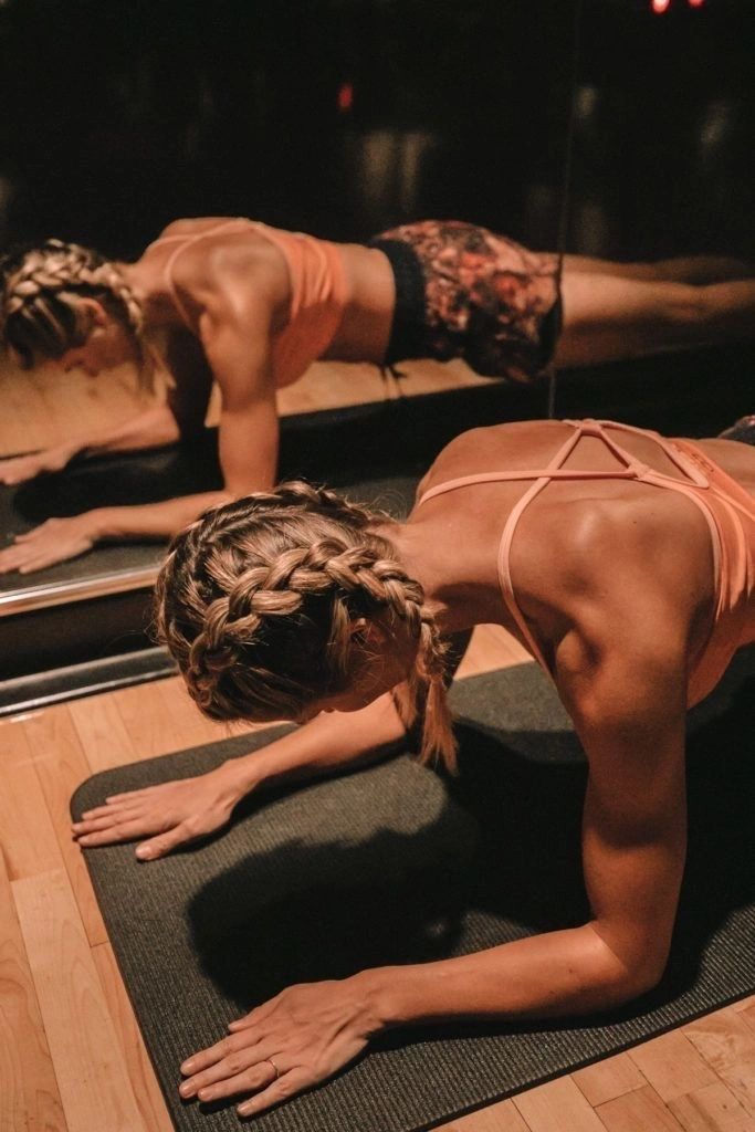 Member holding a plank on a mat in the infrared studio
